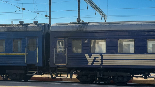 Khmelnytskyi, Ukraine - March 12, 2026: Ukrzaliznytsia train carriages parked at a station, conveying public transport services and long distance travel across the landscape
