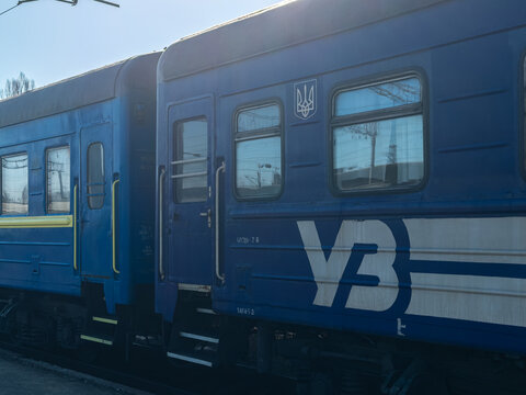 Khmelnytskyi, Ukraine - March 12, 2026: Ukrzaliznytsia passenger train cars parked at a station platform on a sunny day, showcasing regional public rail transport infrastructure