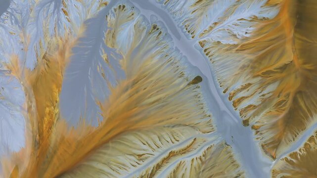 Aerial view of abstract mining pattern, nature pollution, colorful decanting lake by drone