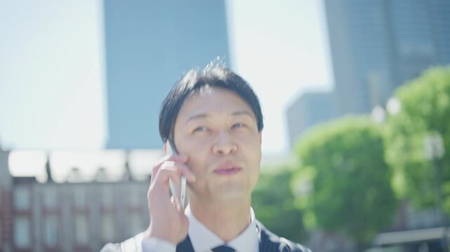 Businessman making a phone call in front of Tokyo Station