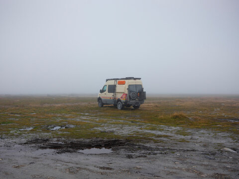 Off-road vehicle in misty countryside fields