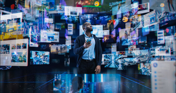 Black Man Holding Mobile smartphone and Looking up at Immersive Wall of Holographic Media Windows, Exploring Feed of Videos, Emoji Reactions and Web Pages. Social Network, Streaming, Ai Content.