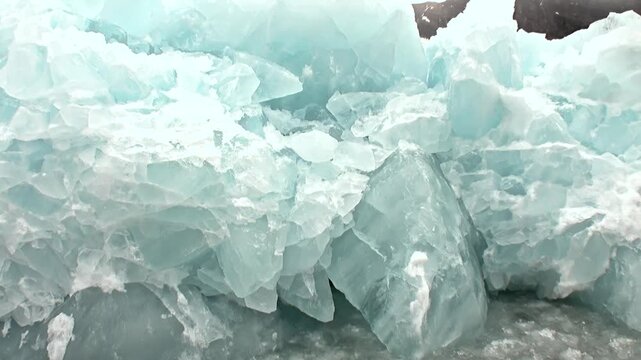 Fractured Pale Turquoise Ice Blocks in Cold Ice Detail Setting. The composition includes a close view of layered pale blue ice with broken crystalline edges.