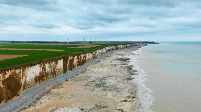 Long stretch of Normandy shoreline with chalk cliffs and beach, drone view. Coastal landscape in northern France with natural cliff edge and tidal zone