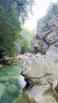 Breathtaking vertical video of a hidden canyon in Akseki showcasing vibrant turquoise freezing water, mystical atmosphere, and untouched nature