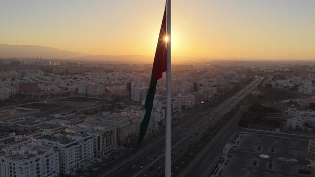 Aerial view of Oman flag over Muscat cityscape, Oman.