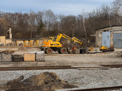 Wroclaw, Poland - March 8, 2026: Terex excavator parked at a rail maintenance depot with industrial tools and construction machinery standing near worn tracks for urban development