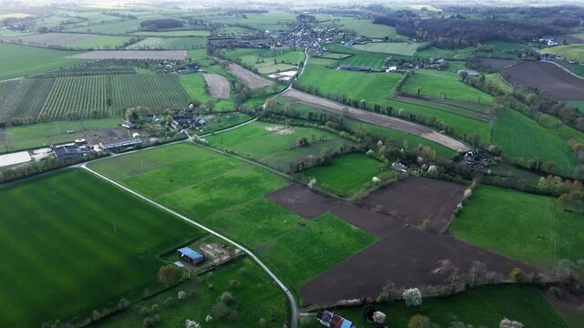 Drone shot of Normandy countryside showing patchwork fields, trees and rural homes across French agricultural region