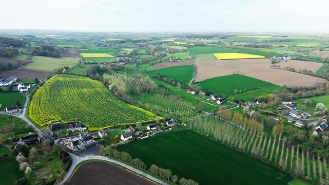 Rural farmland in Normandy, France, with crop fields and farm villages spread across rolling agricultural landscape