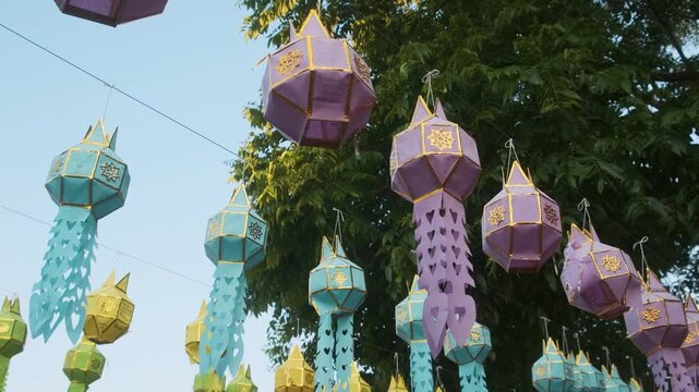 Colorful traditional Lanna lanterns hanging outdoors at Buddhist temple in Chiang Mai, Thailand. Thai cultural decoration, local traditions, religious festivals, handmade crafts and cultural tourism