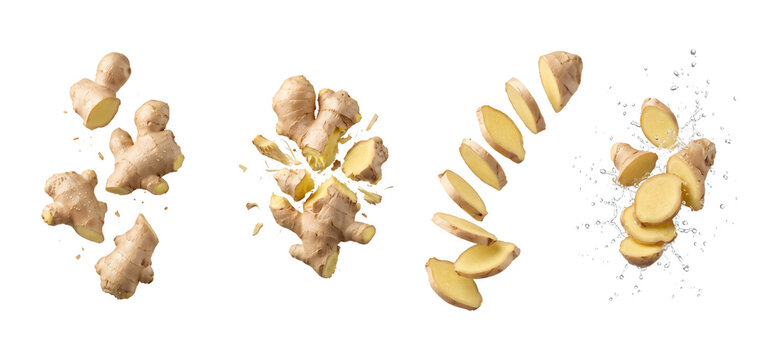 Fresh ginger root pieces and slices falling in the air on a kitchen table