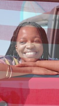 African American woman leaning out of red car door frame outside, with metallic bracelets