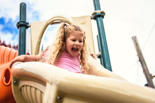 Little girl on a slide outdoors in a park