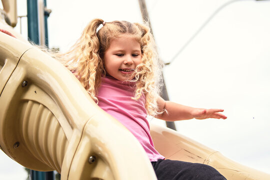 Little girl on a slide outdoors in a park