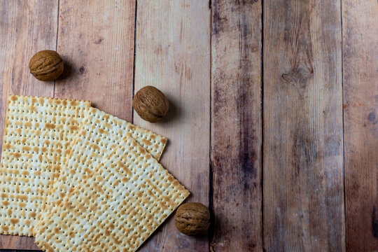Traditional matzo and whole walnuts on rustic wooden table