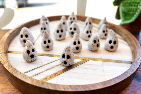 Ghost shaped ceramic salt shakers on round wooden tray in warm sunlight whimsical kitchen shelf idea