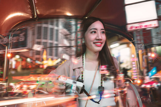 Solo traveler smiling face adult woman sitting tuk tuk taxi local tour explore street journey nightlife travel Bangkok City