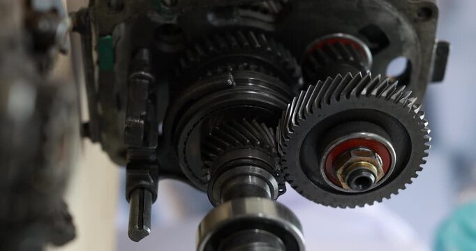 Close-up of exposed metal gears and shafts inside an industrial machine, detailed mechanical parts, lubrication marks, and precision engineering.