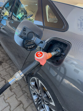 Close-Up of a Fuel Pump Nozzle Inserted into a Car&rsquo;s Gas Tank at a Modern Gas Station for Refueling with 95 Octane Fuel