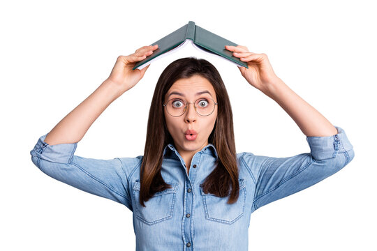Photo of shocked amazed pretty girl hold book above head wear denim shirt isolated on grey color background