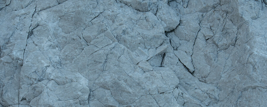 Close Up Gray Rock Texture with Cracks and Rough Fractured Stone Surface Background