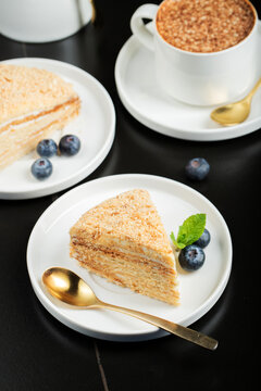 Medovik. Honey cake made from honey cakes with whipped sour cream, decorated with berries, pomegranate and flowers