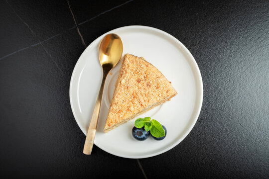 Medovik. Honey cake made from honey cakes with whipped sour cream, decorated with berries, pomegranate and flowers