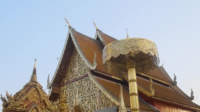 Ornate traditional Lanna temple buildings with golden carvings and colorful decorative gables at Wat Phra That Doi Suthep in Chiang Mai, Thailand. Buddhist architecture, Thai culture