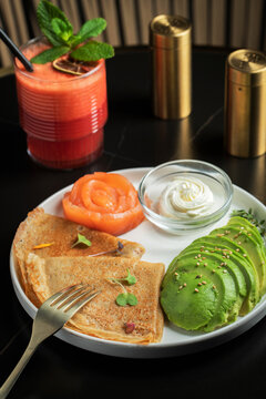 Roasted thin pancakes with smoked salmon and sauce
