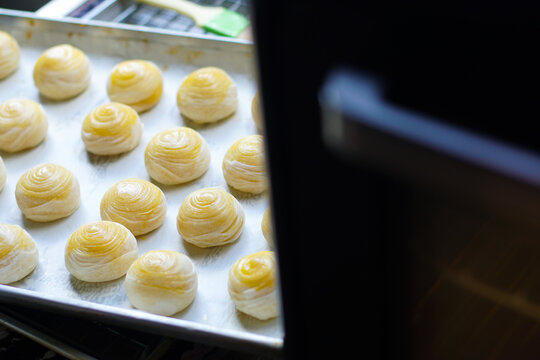 Toasted Mung Bean Cake from the oven. Chinese pastry or moon cake filled with sweet mung bean paste and salted egg yolk. Delicious pastry.