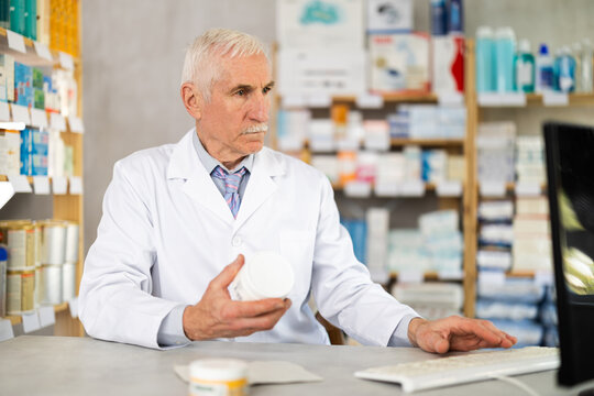 Male pharmacist looking for cream on computer