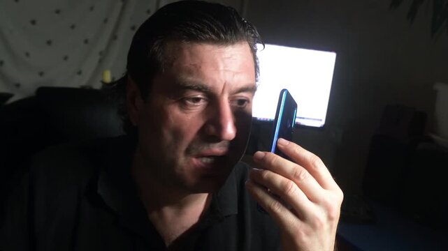 The person on the other end of the line is so abrasive that the man has to pull the phone away from his ear.
