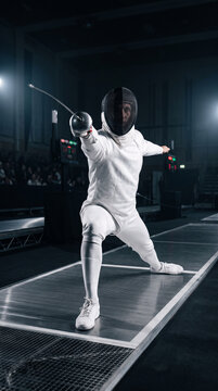 Fencer in white protective gear performing lunge attack with foil blade