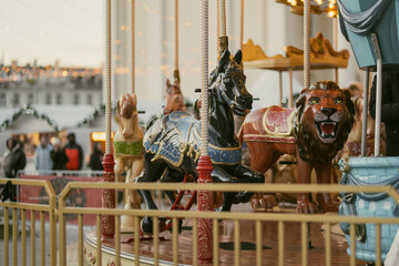 Christmas carousel with colorful animal figures at Cathedral Square in Vilnius, Lithuania. Festive amusement ride and holiday lights create a cheerful winter atmosphere. © MNStudio