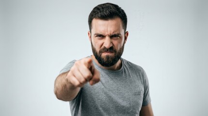 Fototapeta premium Young man pointing his finger in a studio with a gray background
