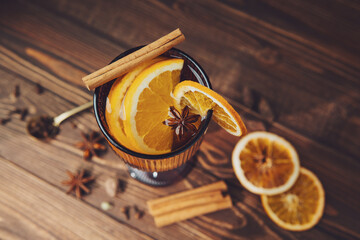 Mulled wine with orange and cinnamon on a wooden table © reddish