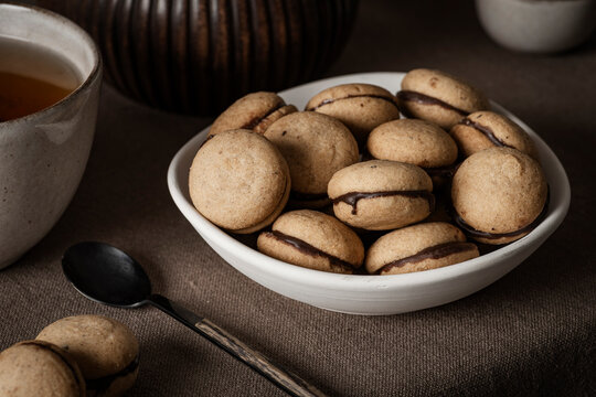 Italian 'Baci di dama', shot from the front to highlight their shape and the thin layer of chocolate cream that joins the two halves.