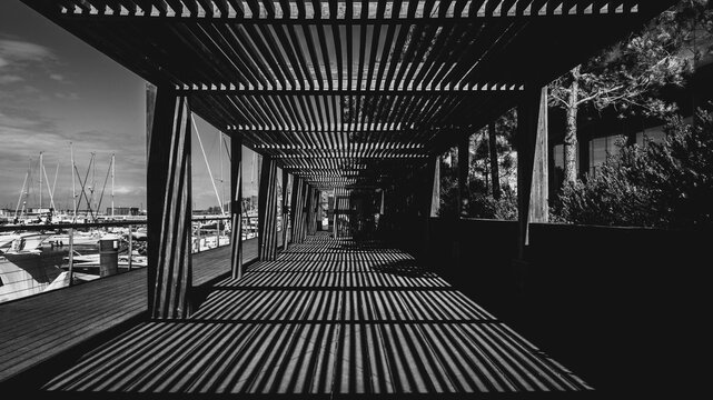 Dramatic light and shadow on wooden pergola in Troia Marina, Portugal