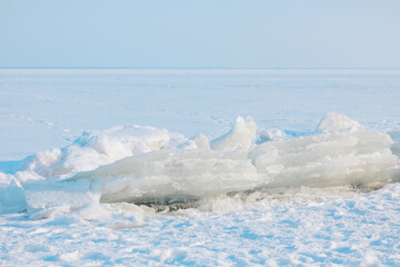 Vast frozen landscape featuring large fractured ice formations resting on a snowy surface © reddish