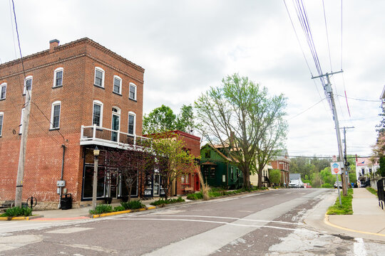 Brick street scene with storefronts and trees