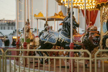 Christmas carousel with colorful animal figures at Cathedral Square in Vilnius, Lithuania. Festive amusement ride and holiday lights create a cheerful winter atmosphere. © MNStudio