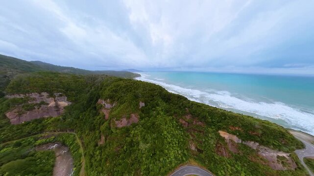 Aerial view of New Zealand, forested coastlines and winding cliffside roads
