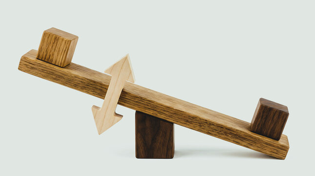 Wooden seesaw balance scale with light brown cubes on wooden plank represents stability and financial concepts