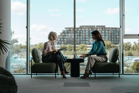 Businesswomen meeting collaborating and discussing in modern office