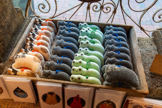 Colorful frog slipper socks on display in wooden crate at market stall