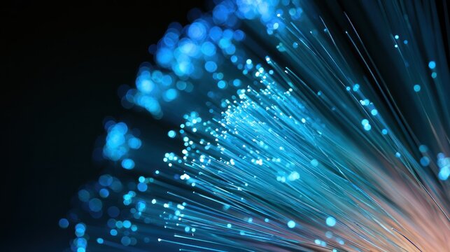 Close up of glowing blue fiber optic strands against a dark background