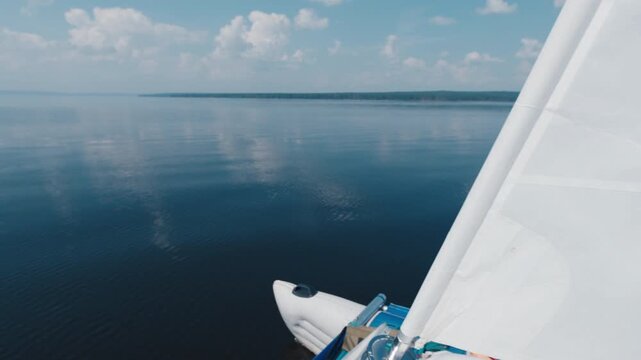 Sailing boat moves on the calm lake