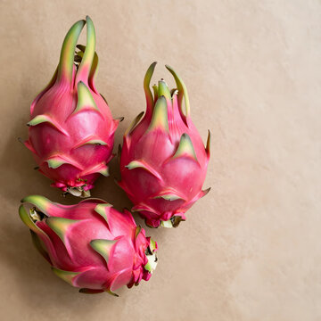 Healthy nutrition and superfood concept, three fresh dragon fruits or pitaya on a rustic brown paper background for organic diet and wellness lifestyle