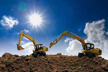 Two Crawler excavator  digging the soil  ,In the construction site on sunlight background. © chaphot