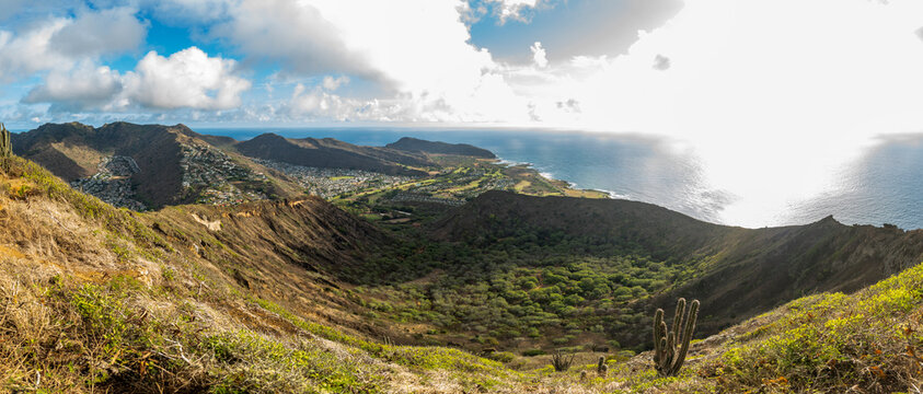Volcanic crater valley overlooking ocean coastline under blue sky